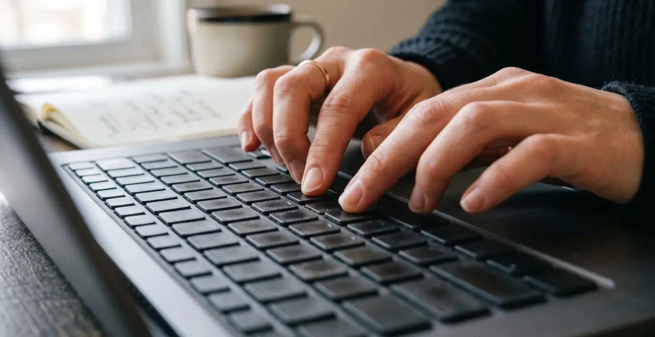 Professionista concentrato che studia su laptop in ambiente domestico professionale con luce naturale